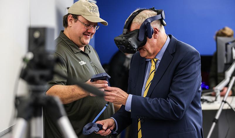 Mount Mercy President, Dr. 托德一. Olson, demonstrates virtual reality equipment